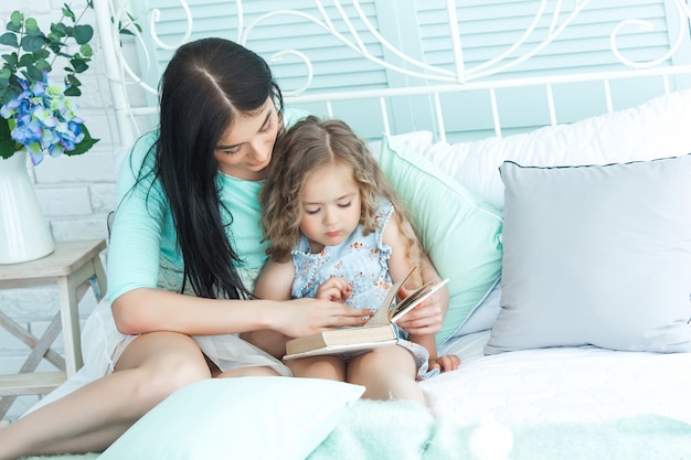 Madre amorevole che legge una storia della buonanotte a suo figlio