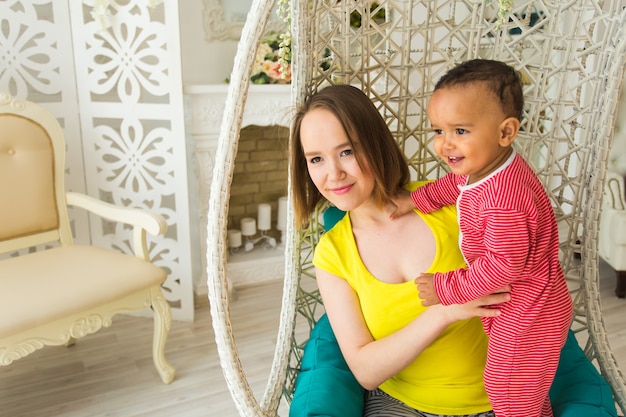 Madre amorosa che tiene il figlio del bambino della corsa mista a casa.