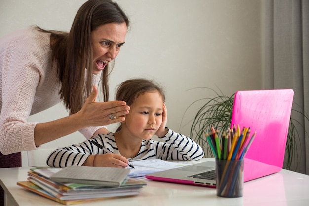 Madre arrabbiata e figlia annoiata durante la lezione online