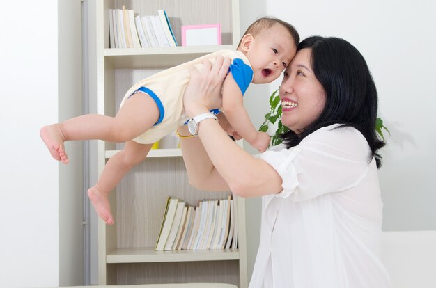 Madre asiatica che gioca con il suo bambino