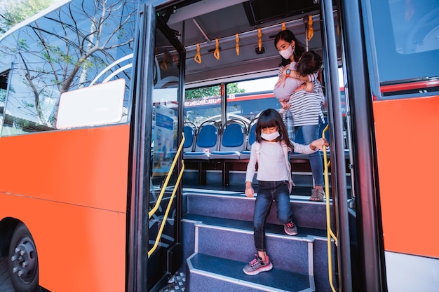 Madre asiatica che porta sua figlia a scuola in autobus con i mezzi pubblici