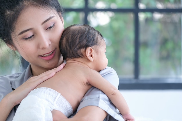 Madre asiatica con in braccio un bambino di 1,5 mesi