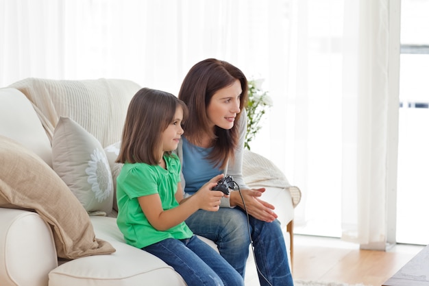 Madre attenta che incoraggia sua figlia a giocare ai videogiochi