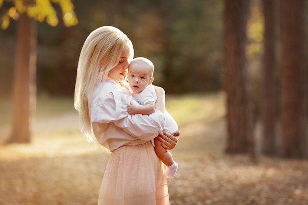 madre che abbraccia il suo bambino paesaggio autunnale passeggiata nella natura all'aperto maternità in famiglia genitorialità