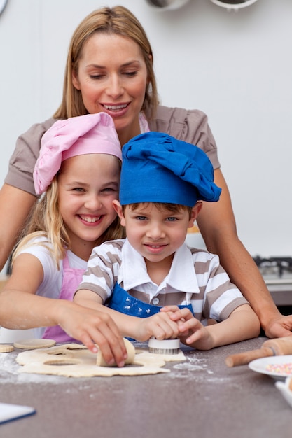 Madre che aiuta i suoi bambini a cuocere