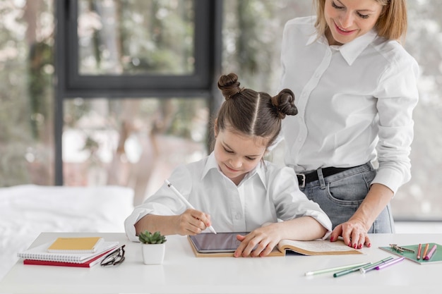 Madre che aiuta sua figlia a studiare a casa