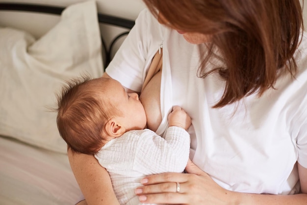 Madre che allatta al seno il suo neonato Ritratto domestico realistico