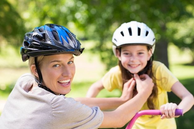 Madre che alleva il casco da bicicletta delle sue figlie