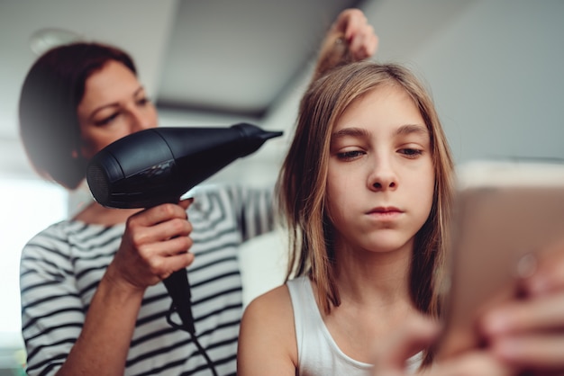 Madre che asciuga i capelli a sua figlia