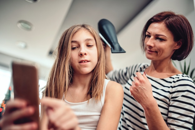 Madre che asciuga i capelli a sua figlia