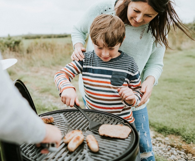 Madre che assiste il bambino mentre griglia