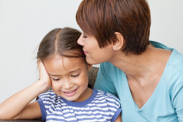 Madre che bacia sua figlia con amore e cura