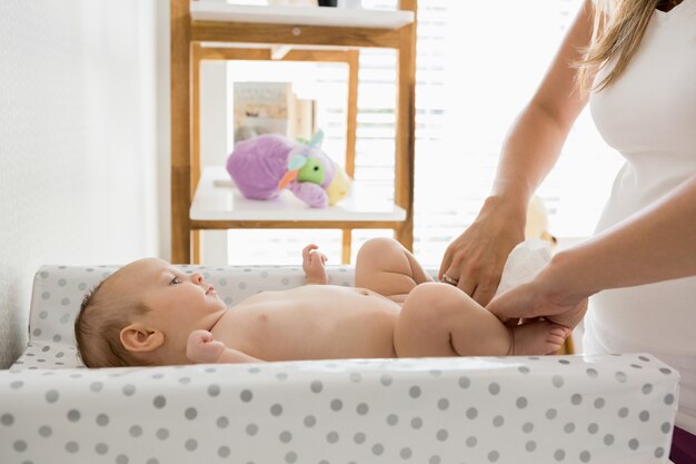 Madre che cambia il pannolino del suo bambino