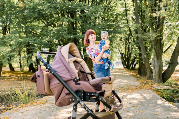 Madre che cammina con passeggino carrozzina, carrozza in città. Amore e concetto di famiglia.