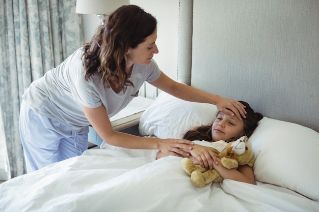 Madre che fa dormire sua figlia in camera da letto