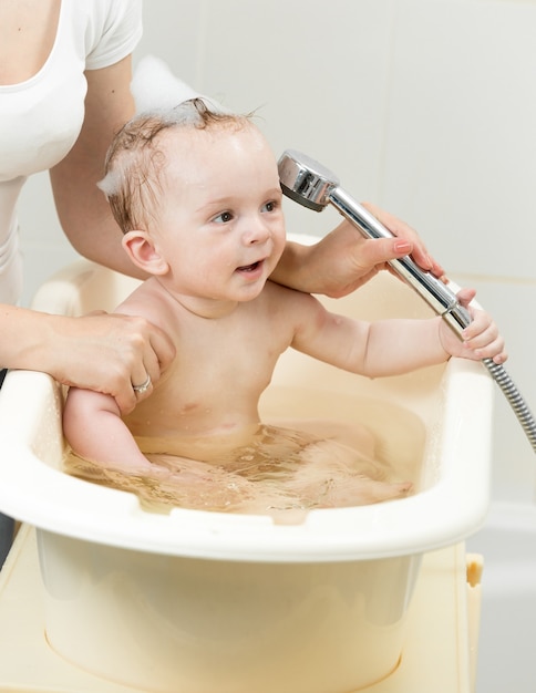 Madre che fa il bagno al suo bambino carino in bagno