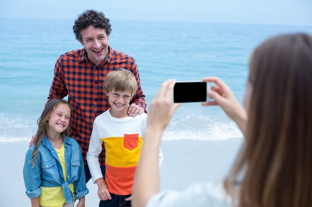 Madre che fotografa famiglia allegra