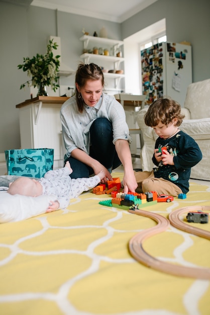 Madre che gioca con il figlio sul pavimento a casa