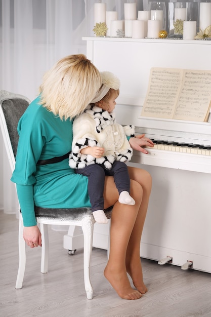 Madre che insegna a sua figlia a suonare il pianoforte