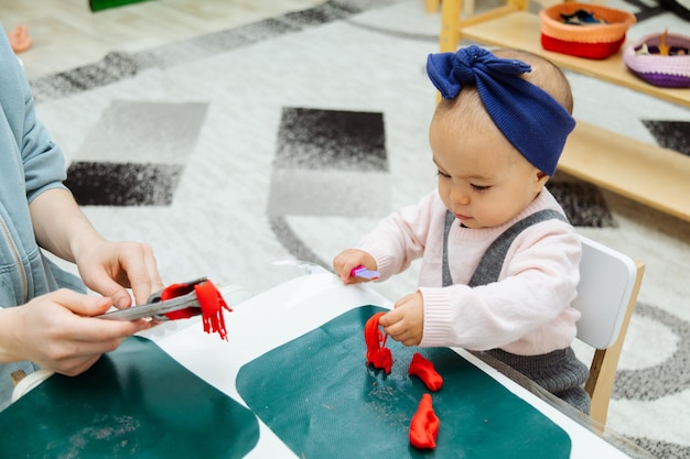 Madre che insegna al bambino a creare forme con PlayDoh