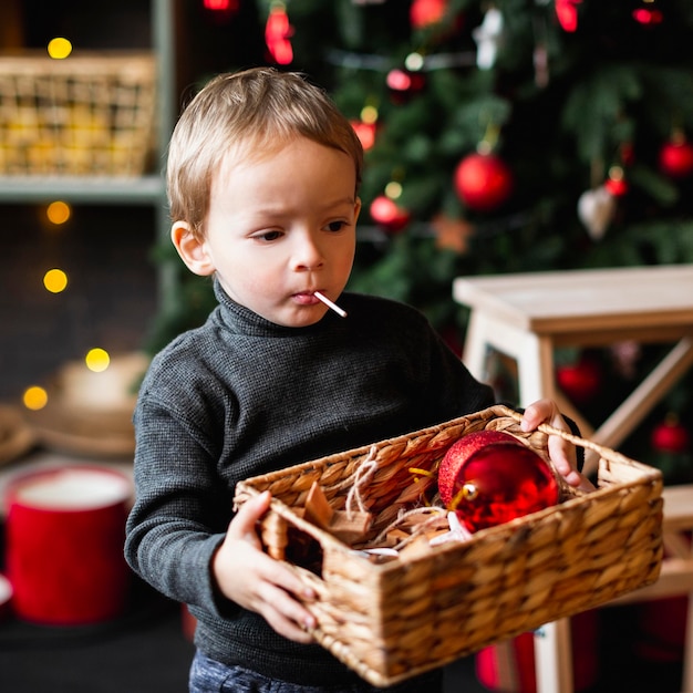 Madre che insegna al figlio come decorare l'albero di Natale