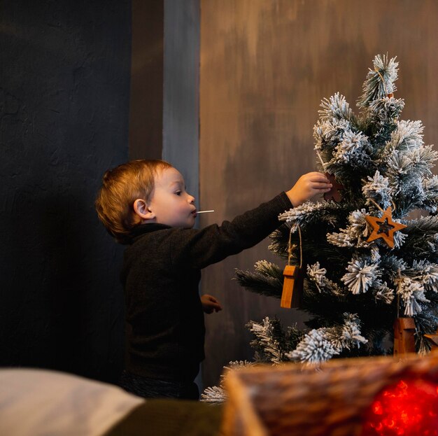 Madre che insegna al figlio come decorare l'albero di Natale