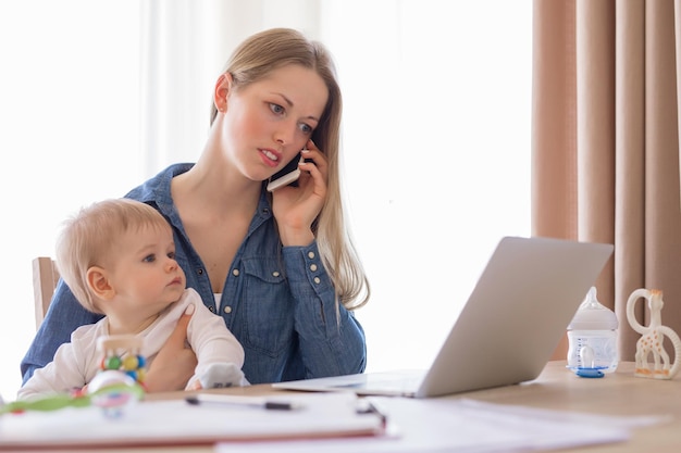 Madre che lavora con il bambino in grembo che lavora da casa