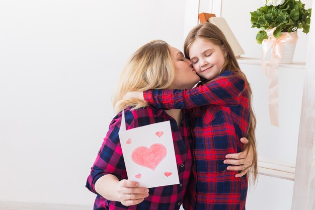 Madre che legge la cartolina d'auguri da sua figlia