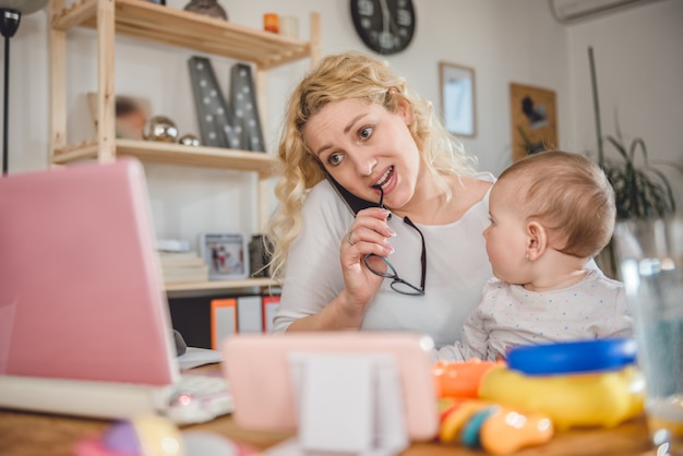 Madre che parla sull'ufficio dello Smart Phone a casa