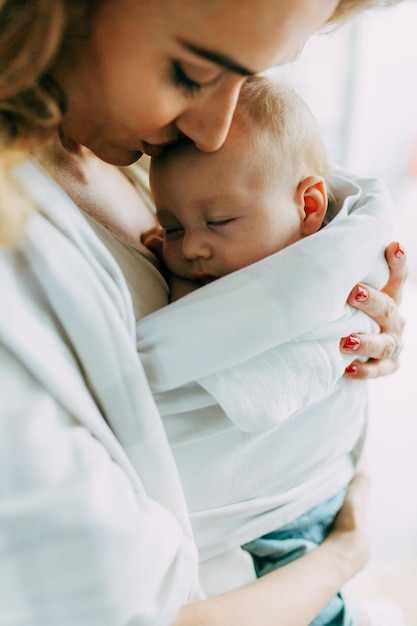 Madre che porta in braccio il neonato a casa
