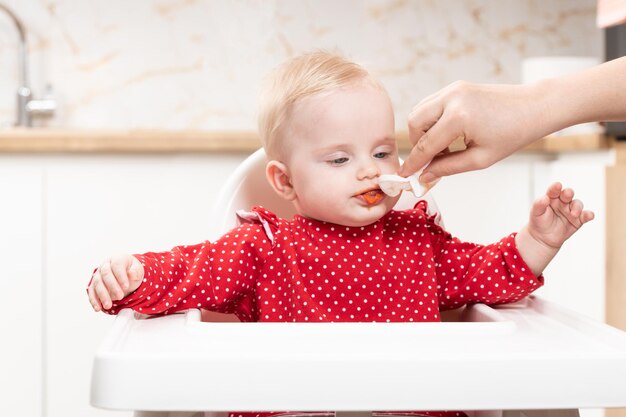 Madre che pulisce la bocca del bambino affamato