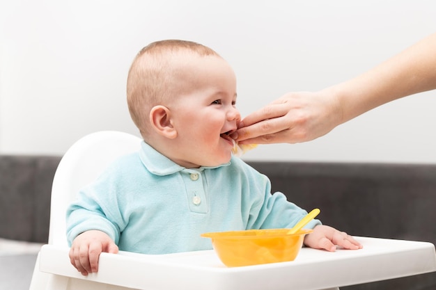 Madre che pulisce la bocca del bambino affamato