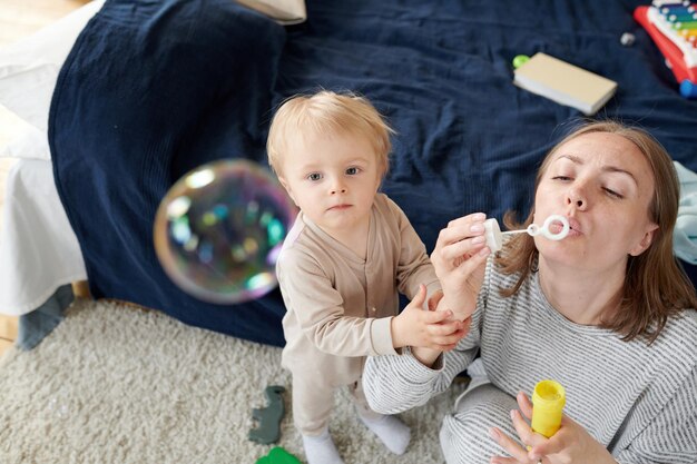 Madre che soffia bolle con il bambino