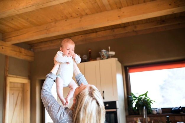 Madre che solleva il bambino a casa