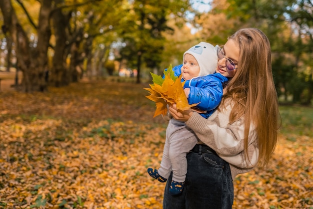 Madre che tiene il bambino in braccio nel parco