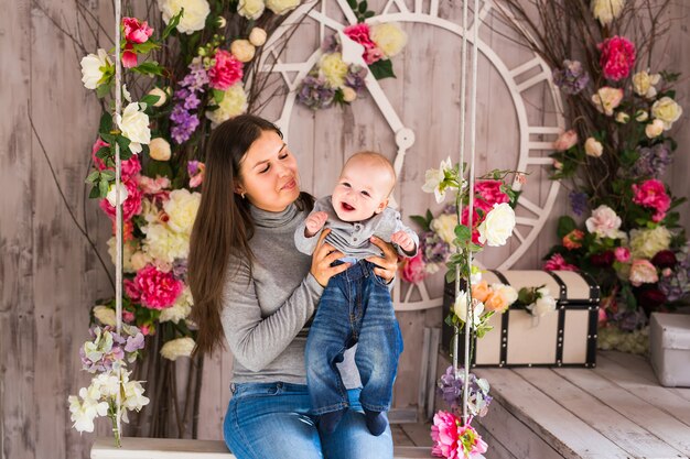 Madre che tiene il suo bambino. Mamma che gioca con il bambino che ride. Famiglia a casa.