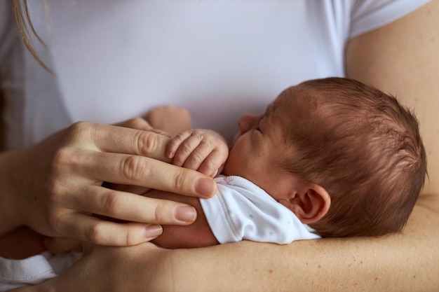 Madre che tiene in mano il suo neonato