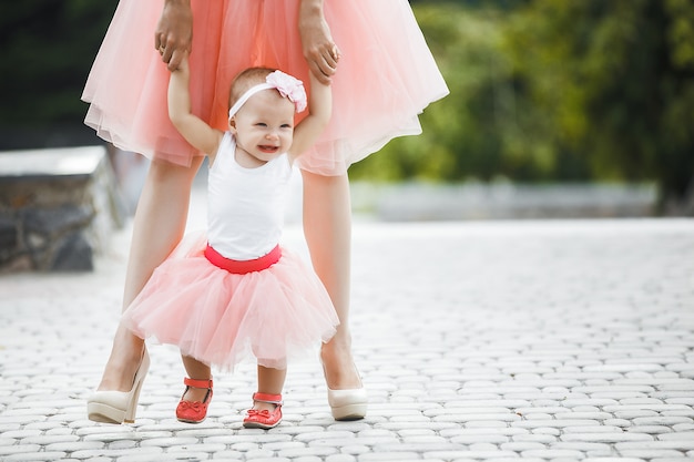 madre che tiene la sua piccola bambina per mano