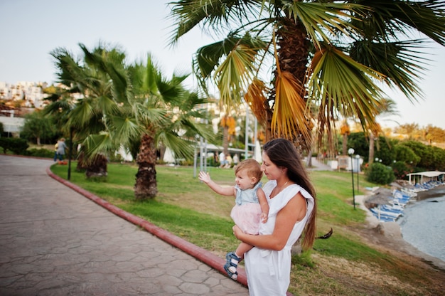 Madre con bambina in Turchia resort contro le palme.