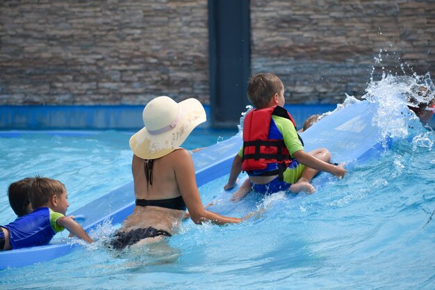 Madre con bambini al parco acquatico