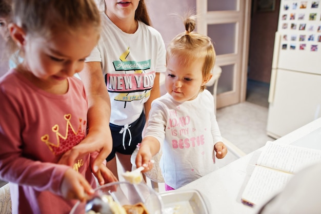 Madre con bambini che cucinano in cucina momenti felici per bambini