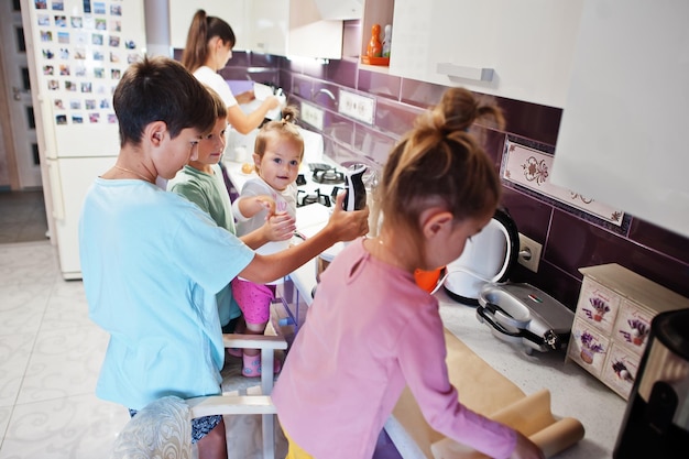 Madre con bambini che cucinano in cucina momenti felici per bambini