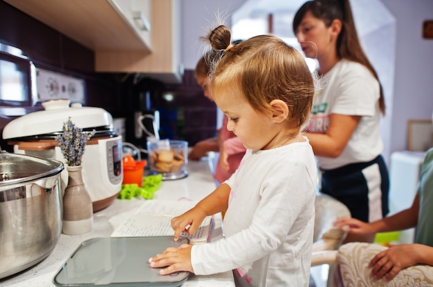 Madre con bambini che cucinano in cucina, momenti felici per bambini.