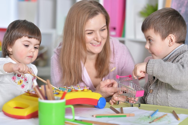 Madre con bambini che giocano insieme a casa