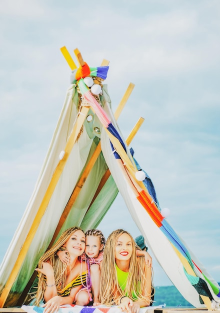 Madre con bambini che giocano insieme in tenda campeggio in famiglia mamma con bambini che si divertono all'aperto vacat