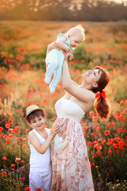 madre con bambini in estate campo di papaveri