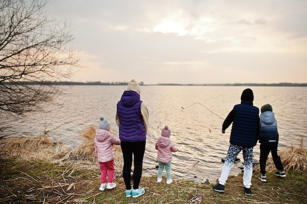 Madre con bambini in riva al lago