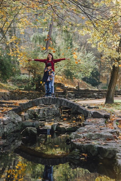 Madre con bambino che riposa al parco pubblico della città d'autunno. copia spazio