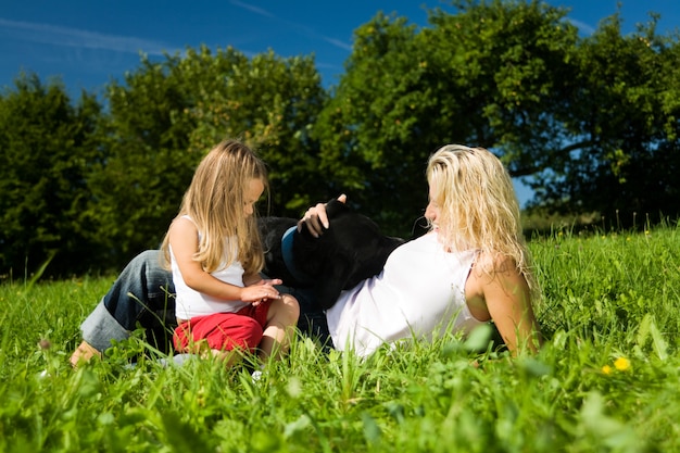 Madre con bambino e cane sull'erba