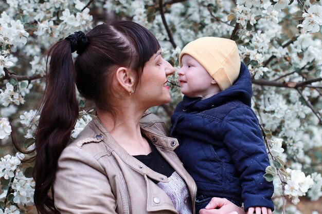 Madre con bambino in un albero della foresta di una giornata di sole del giardino estivo